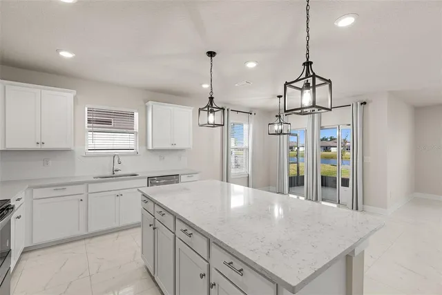 a kitchen with a sink a center island and cabinets