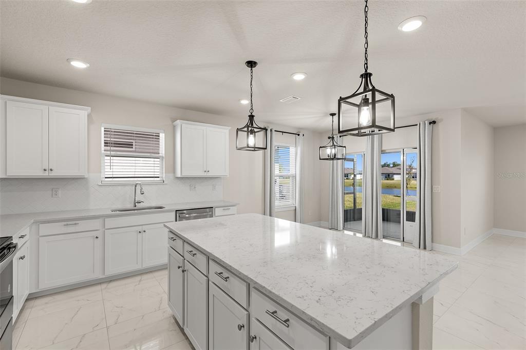 9256 Royal River Circle Parrish, FL 34219 - Photo 11 of 38 a kitchen with a sink a center island and cabinets