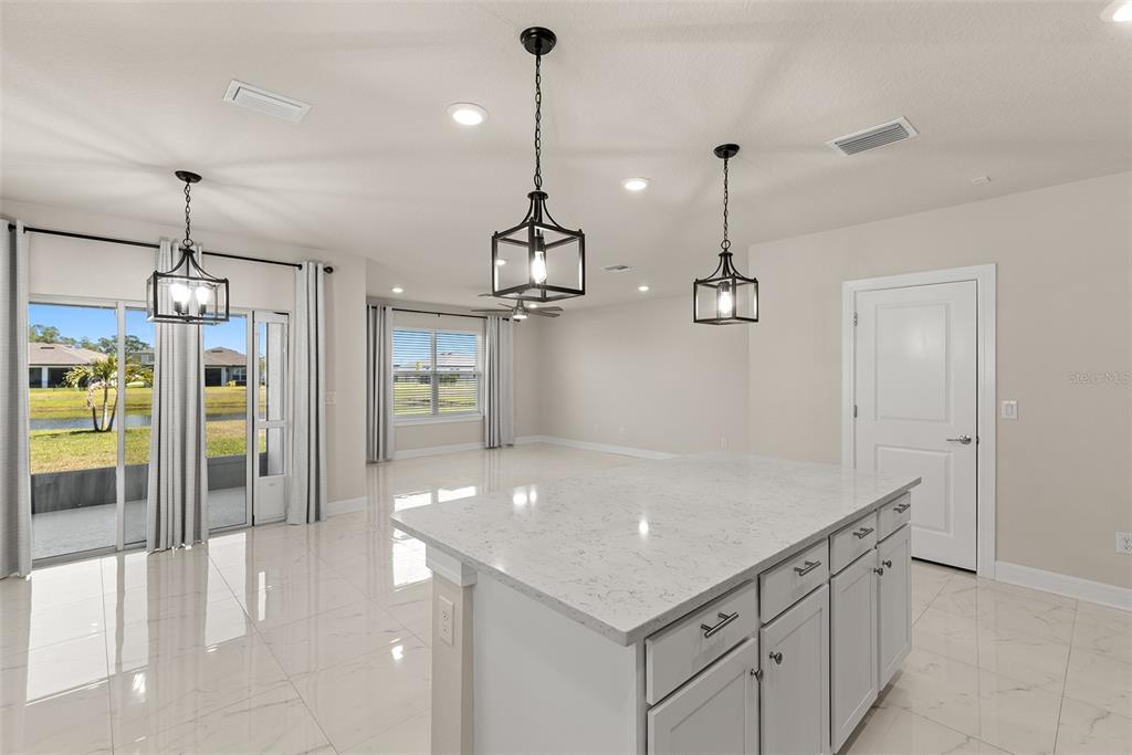 9256 Royal River Circle Parrish, FL 34219 - Photo 12 of 38 a kitchen with a refrigerator a sink and chandelier