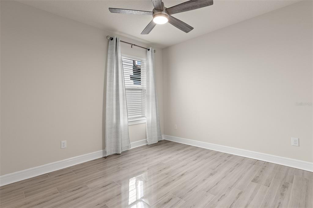 9256 Royal River Circle Parrish, FL 34219 - Photo 26 of 38 an empty room with wooden floor chandelier fan and windows