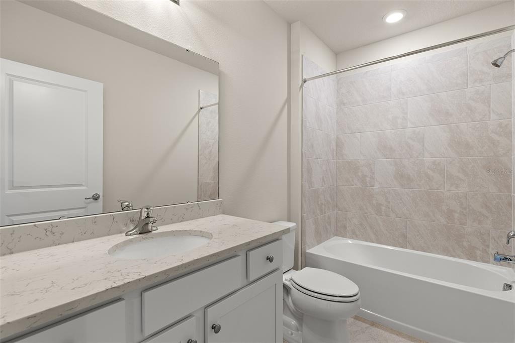 9256 Royal River Circle Parrish, FL 34219 - Photo 29 of 38 a bathroom with a granite countertop sink a toilet and a bathtub