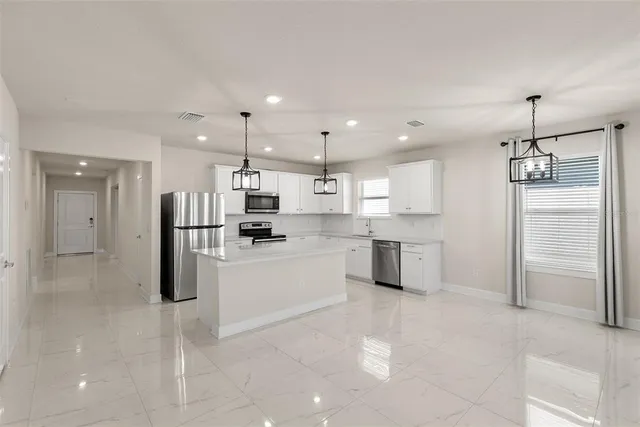 a kitchen with white cabinets and stainless steel appliances