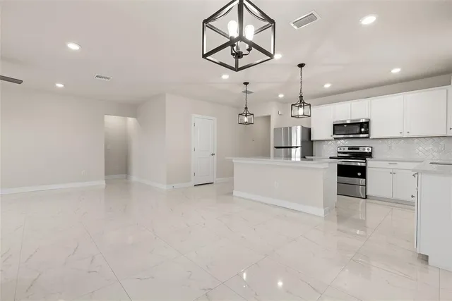 a view of kitchen with microwave and cabinets
