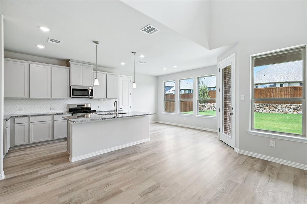 509 Hummingbird Lane Van Alstyne, TX 75495 - Photo 2 of 40 a large kitchen with stainless steel appliances granite countertop a stove a sink and a large window