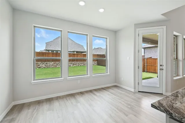 a kitchen with stainless steel appliances granite countertop a sink a stove and a wooden floors