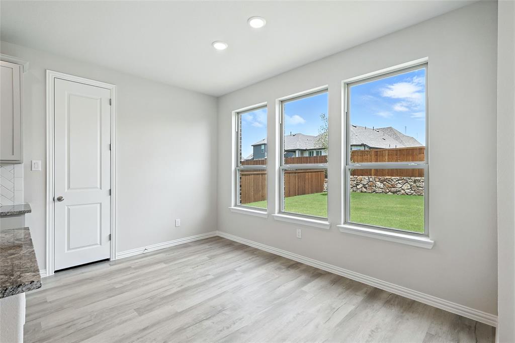 509 Hummingbird Lane Van Alstyne, TX 75495 - Photo 7 of 40 a view of an empty room with a window and wooden floor