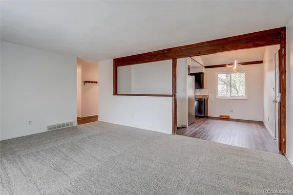 a view of empty room with wooden floor and fireplace