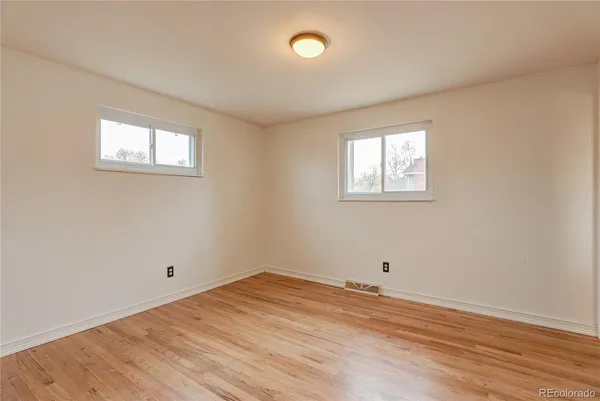 a view of empty room with wooden floor