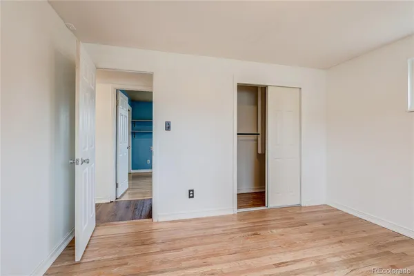 a view of an empty room with wooden floor