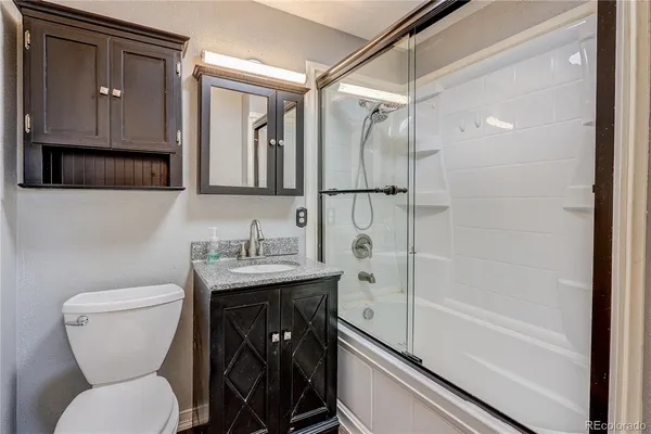 a bathroom with a granite countertop sink toilet and shower