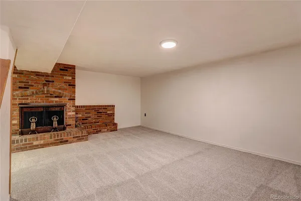 a view of an empty room with fire place and a fireplace