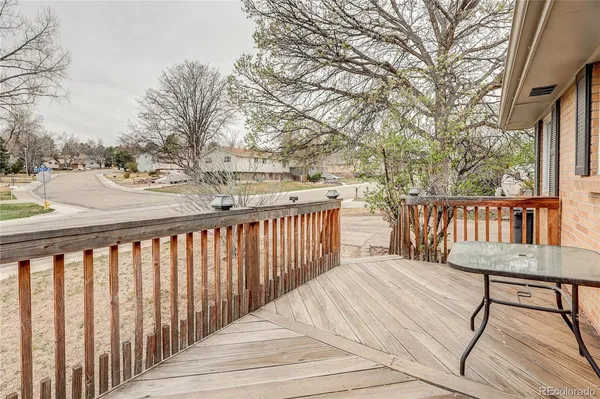 a balcony with wooden floor table and chairs