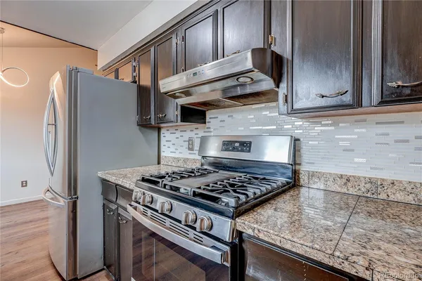 a kitchen with stainless steel appliances granite countertop a stove and a refrigerator