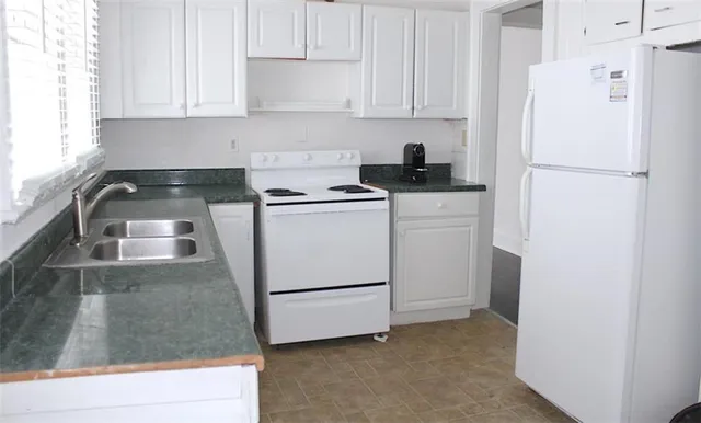 a kitchen with a refrigerator sink stove and cabinets