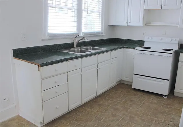 a kitchen with granite countertop white cabinets and white appliances