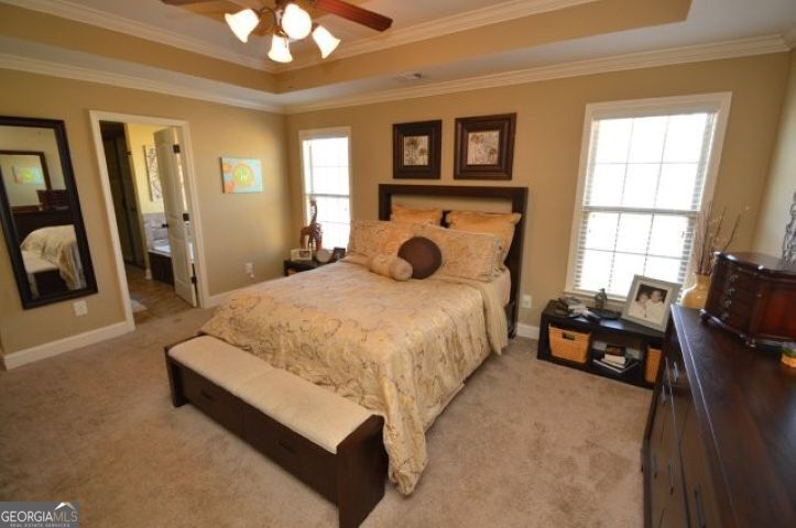 300 Grand Reserve Way Kathleen, GA 31047 - Photo 12 of 24 a spacious bedroom with a bed and a chandelier