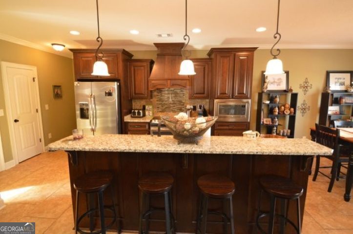 300 Grand Reserve Way Kathleen, GA 31047 - Photo 6 of 24 a dining table with chairs and cabinets