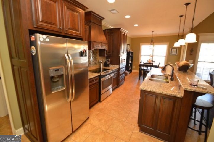 300 Grand Reserve Way Kathleen, GA 31047 - Photo 7 of 24 a kitchen with stainless steel appliances granite countertop a refrigerator a sink dishwasher and a stove with wooden floor