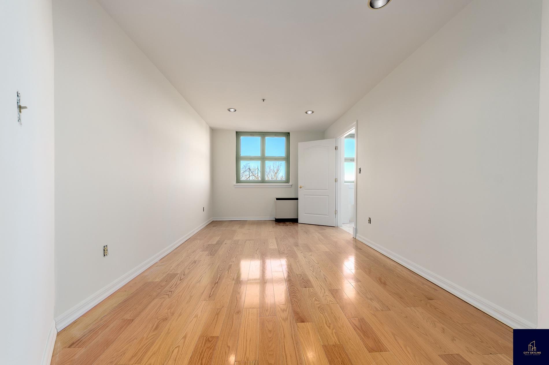19-19 24th Avenue, Unit L607 Queens, NY 11102 - Photo 11 of 15 wooden floor in an empty room with a window