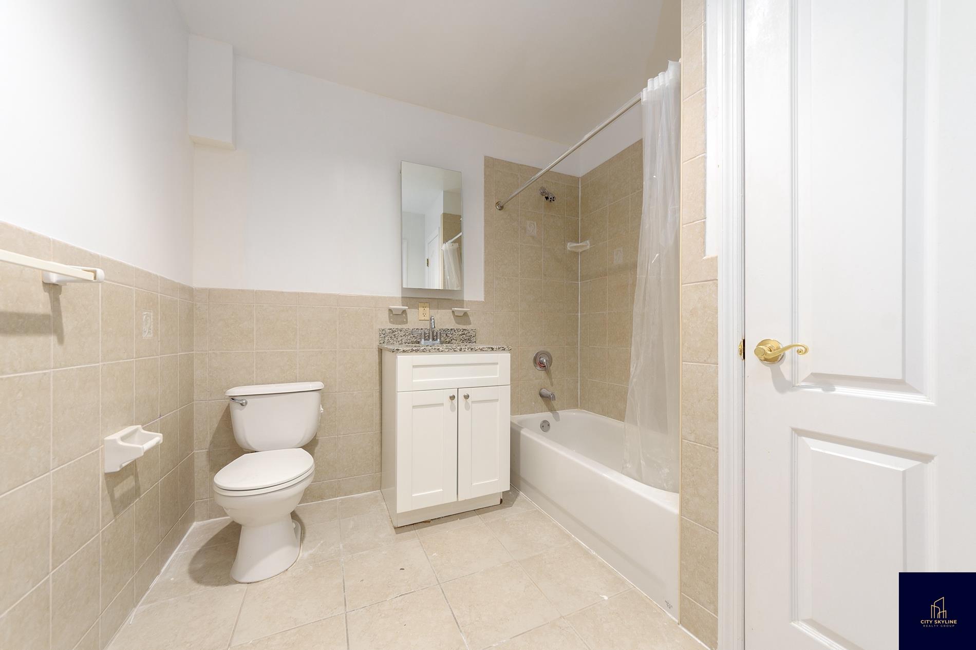 19-19 24th Avenue, Unit L607 Queens, NY 11102 - Photo 13 of 15 a bathroom with a toilet sink and a bathtub