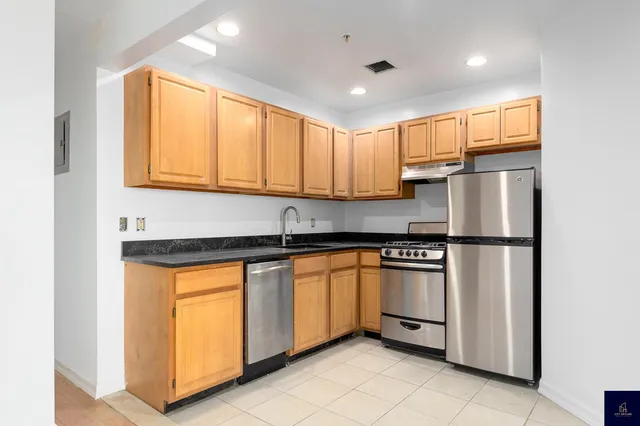 a kitchen with stainless steel appliances granite countertop a refrigerator a sink a stove a microwave and island