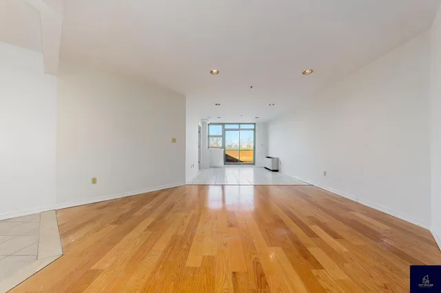 a view of empty room with a window and wooden floor