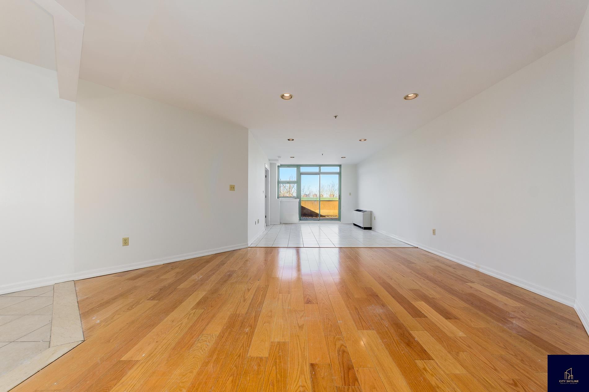 19-19 24th Avenue, Unit L607 Queens, NY 11102 - Photo 7 of 15 a view of empty room with a window and wooden floor