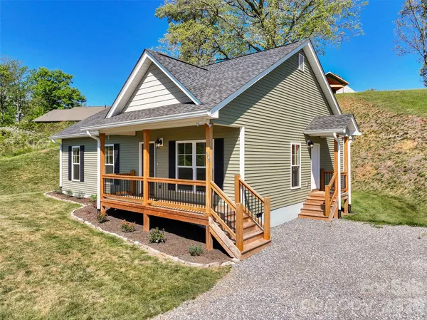 a view of house with a yard and wooden fence