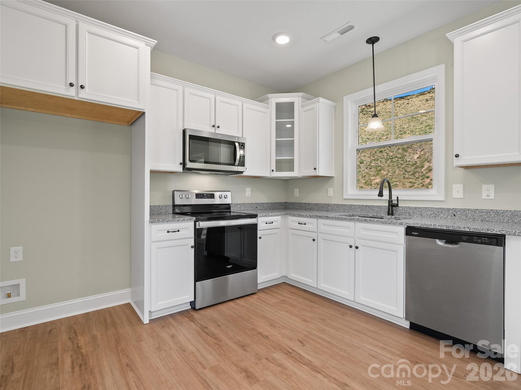 373 Barefoot Ridge Clyde, NC 28721 - Photo 16 of 30 a kitchen with granite countertop a sink stainless steel appliances and white cabinets