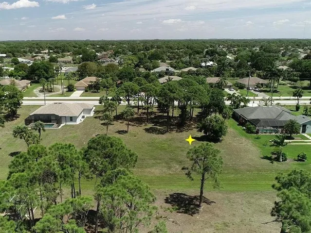 an aerial view of residential houses with outdoor space and trees