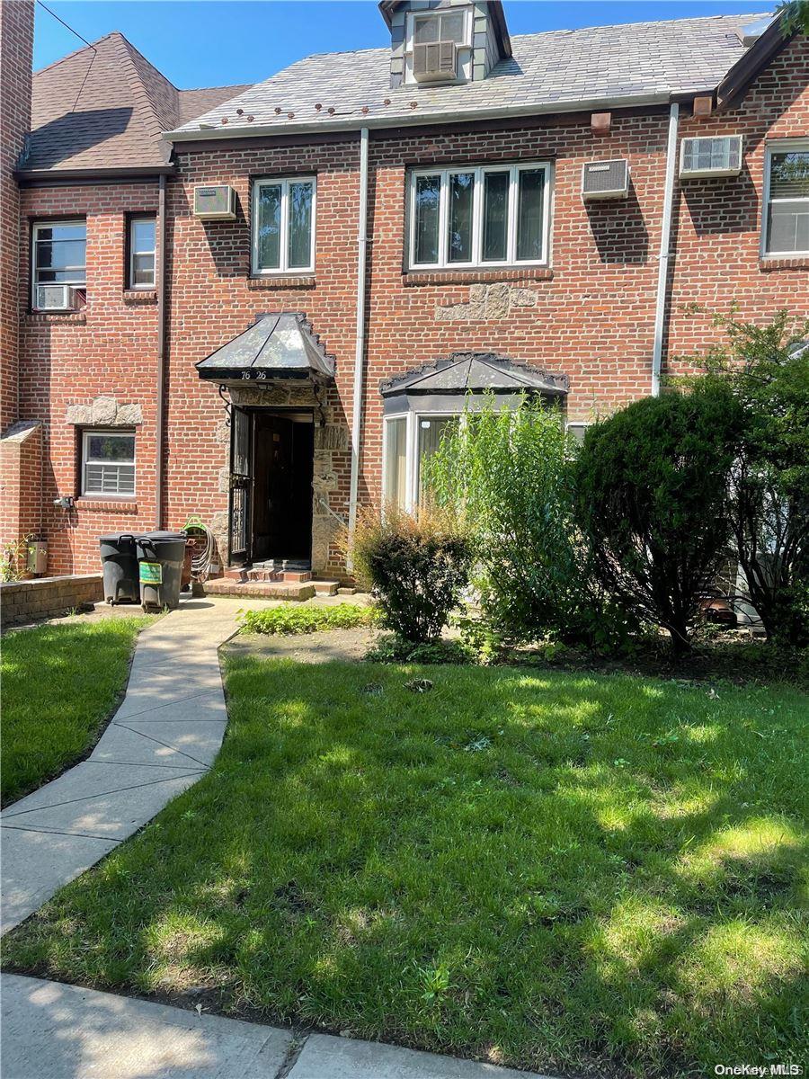 a front view of a house with yard and green space