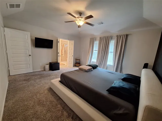 a bedroom with a bed and a flat screen tv