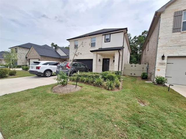a front view of a house with a garden and parking space