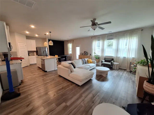 a living room with furniture and a wooden floor