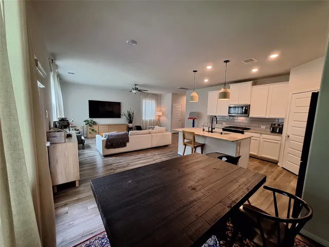 a kitchen with a sink appliances and wooden floor