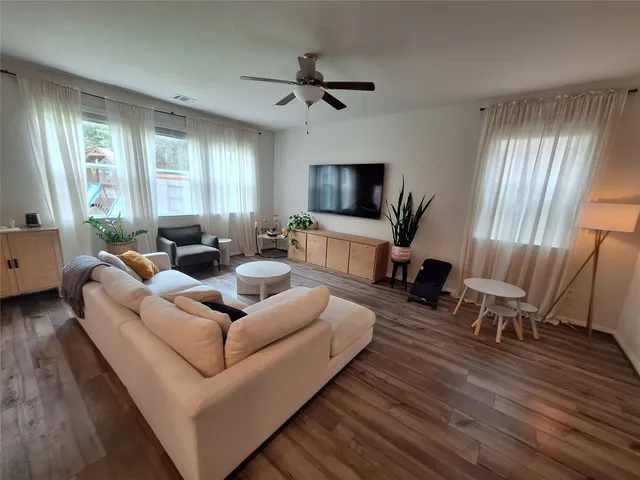 a living room with furniture flat screen tv and window
