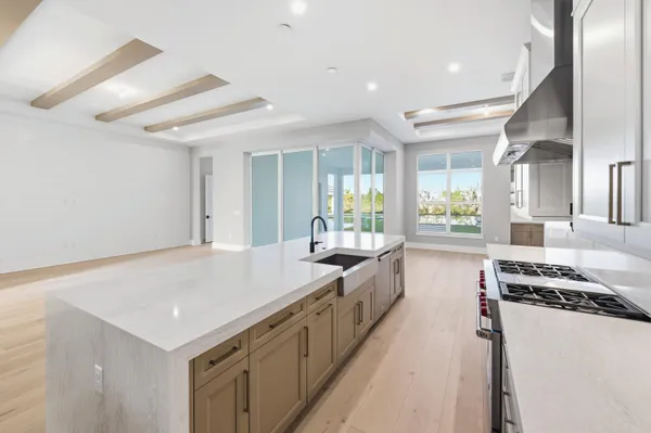 a kitchen with stainless steel appliances kitchen island a table chairs sink and stove top oven