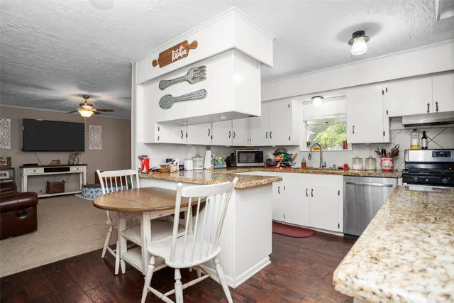 a kitchen with a dining table chairs sink and cabinets