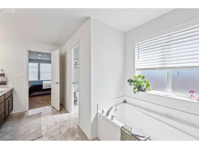 a bathroom with a tub sink and mirror