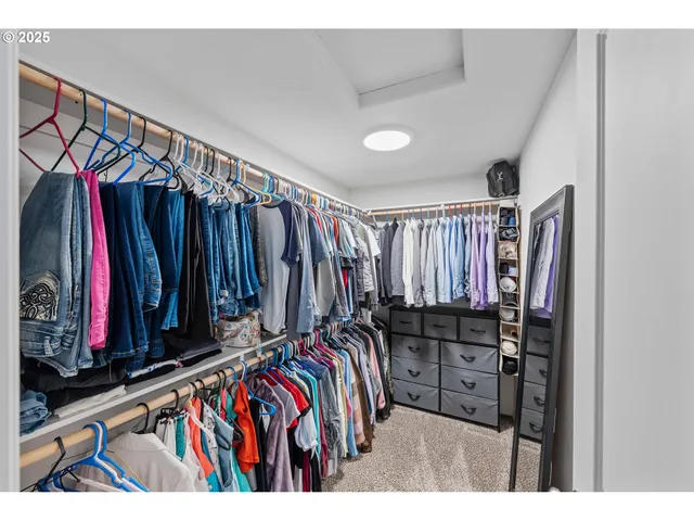 a view of walk in closet with clothes