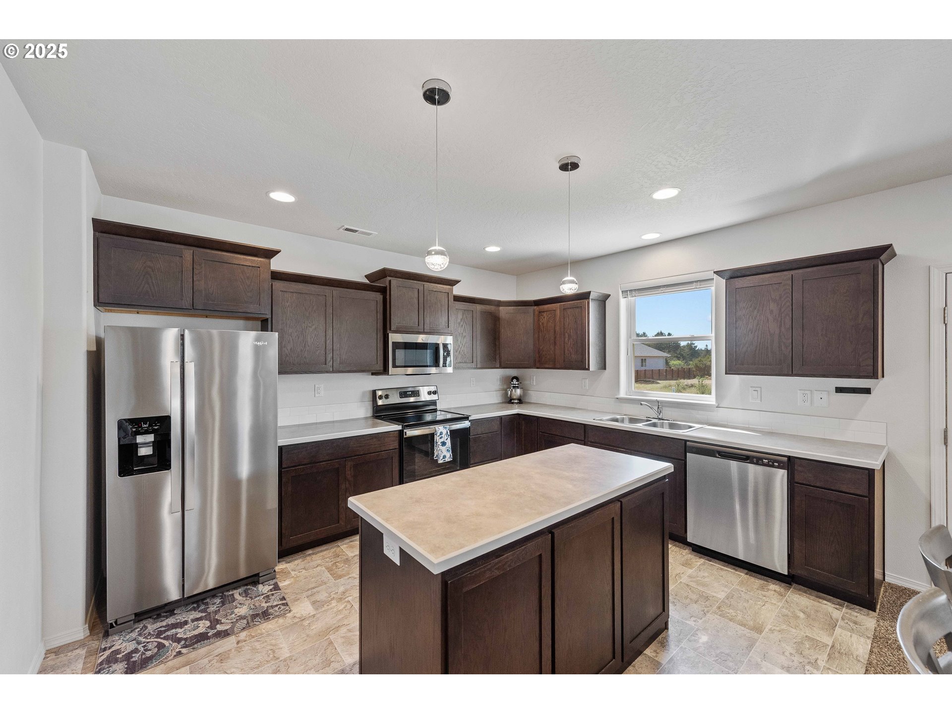 764 Seacrest Drive Bandon, OR 97411 - Photo 9 of 43 a kitchen with stainless steel appliances granite countertop a sink stove refrigerator and cabinets