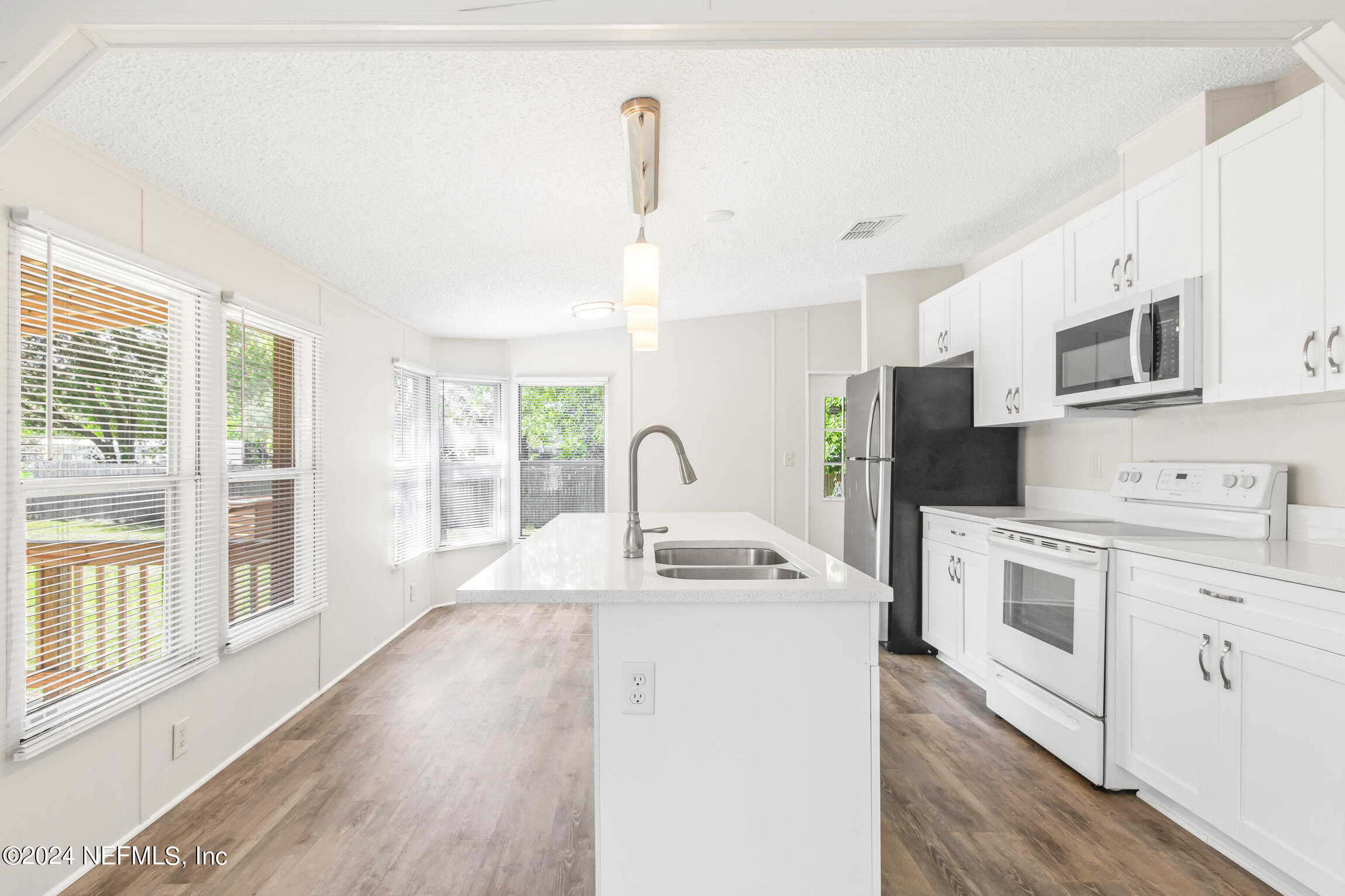 1650 Natalie Road St. Augustine, FL 32084 - Photo 8 of 44 a kitchen with stainless steel appliances granite countertop a stove a sink dishwasher a refrigerator and a microwave oven with wooden floor