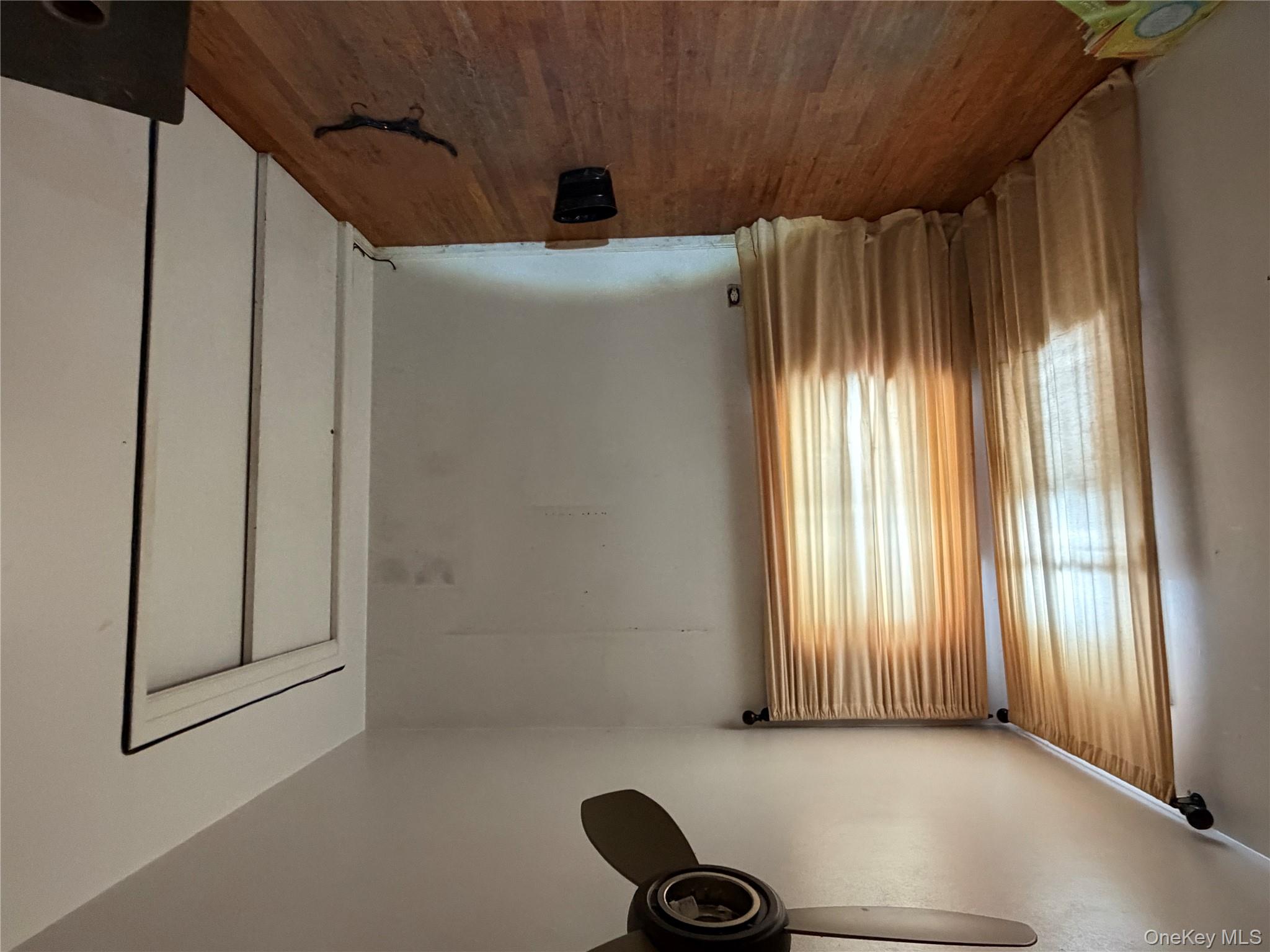 135-26 219th Street Queens, NY 11413 - Photo 34 of 43 an empty room with wooden floor and windows