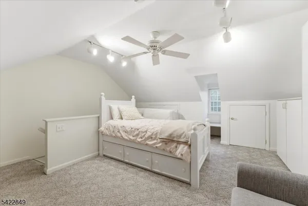 a spacious bedroom with a bed and a ceiling fan
