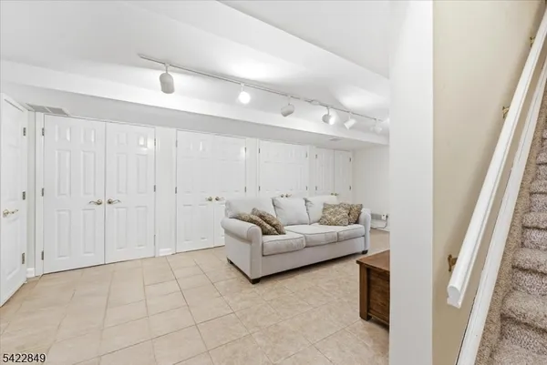 a living room with furniture and a walk in closet with wooden floor