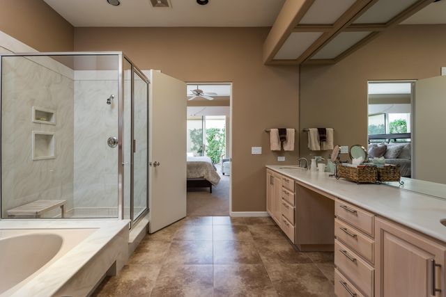 a spacious bathroom with a granite countertop sink mirror bathtub and shower