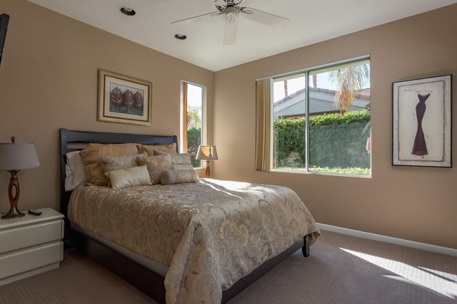 a large bed sitting in a bedroom next to a window