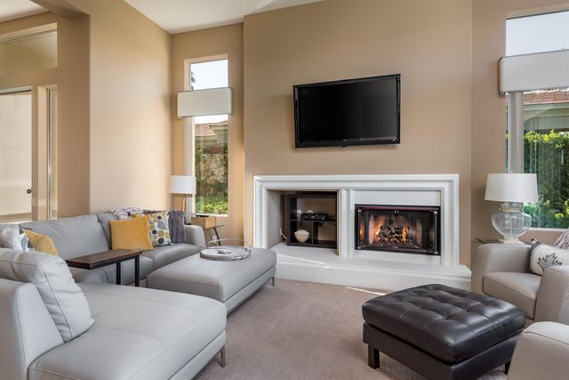 a living room with furniture a fireplace and a flat screen tv