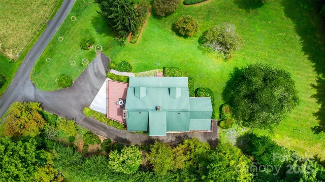 an aerial view of a house with swimming pool and garden