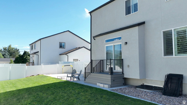 983 South 950 West Provo, UT 84601 - Photo 49 of 56 Expansive backyard featuring a manicured lawn, a white privacy fence, and a concrete patio